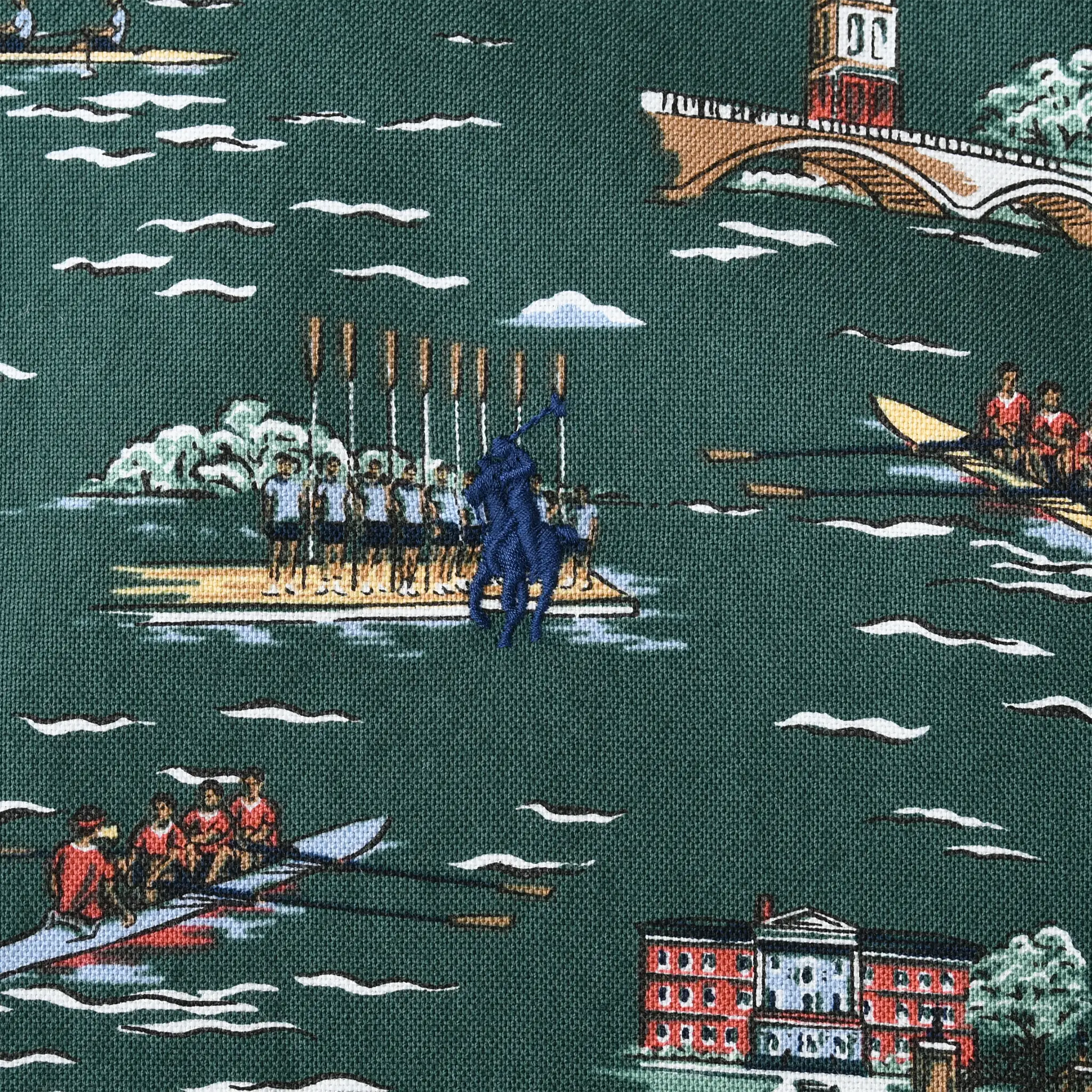 Blue Polo pony embroidery over rowing teams and riverside buildings on green printed fabric