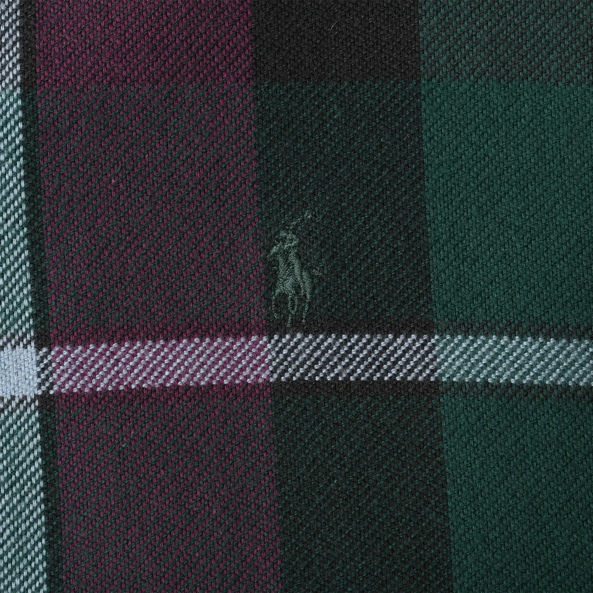 Close-up of tonal Ralph Lauren pony embroidery on dark green and burgundy plaid fabric