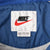 Nike neck label and XXL size tag inside blue windbreaker