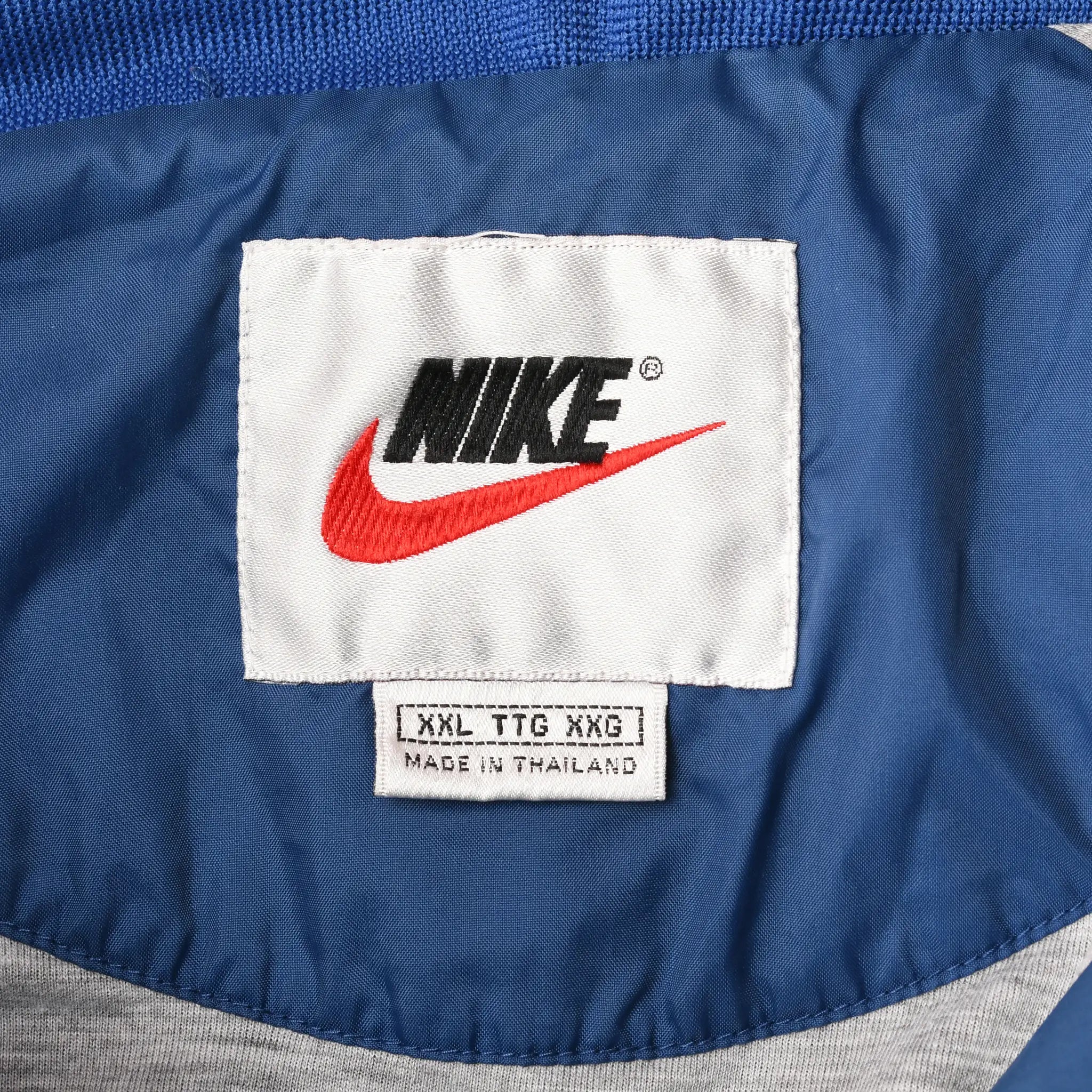 Nike neck label and XXL size tag inside blue windbreaker