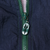 Close-up of green front zipper and Reebok logo zipper pull on navy fabric
