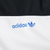 Close-up of blue Adidas trefoil logo embroidered on white front panel