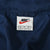 Close-up of Nike neck label inside the navy windbreaker