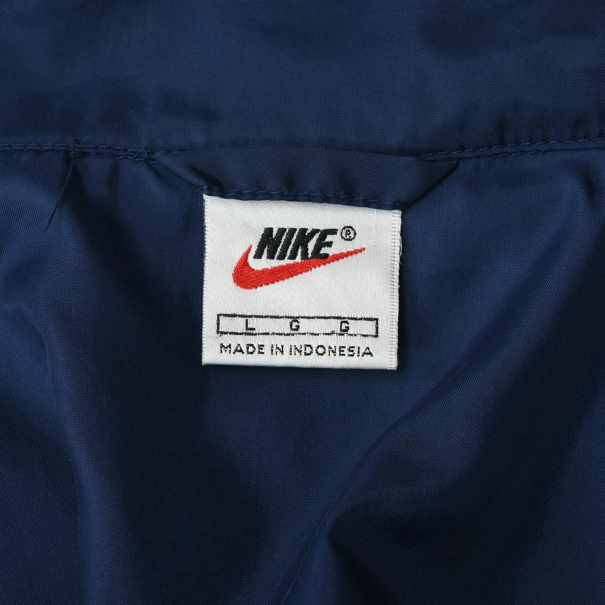 Close-up of Nike neck label inside the navy windbreaker