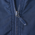 Close-up of the navy windbreaker's front zipper and metal pull