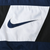Close-up of navy embroidered Nike Swoosh on the white front chest panel