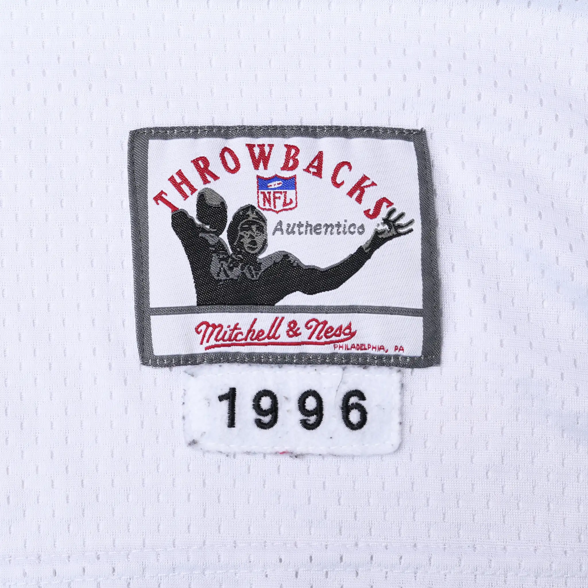 Close-up of Mitchell & Ness Throwbacks NFL hem label with 1996 year tab