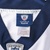 Close-up of NFL Equipment Reebok neck tag and navy V-neck collar