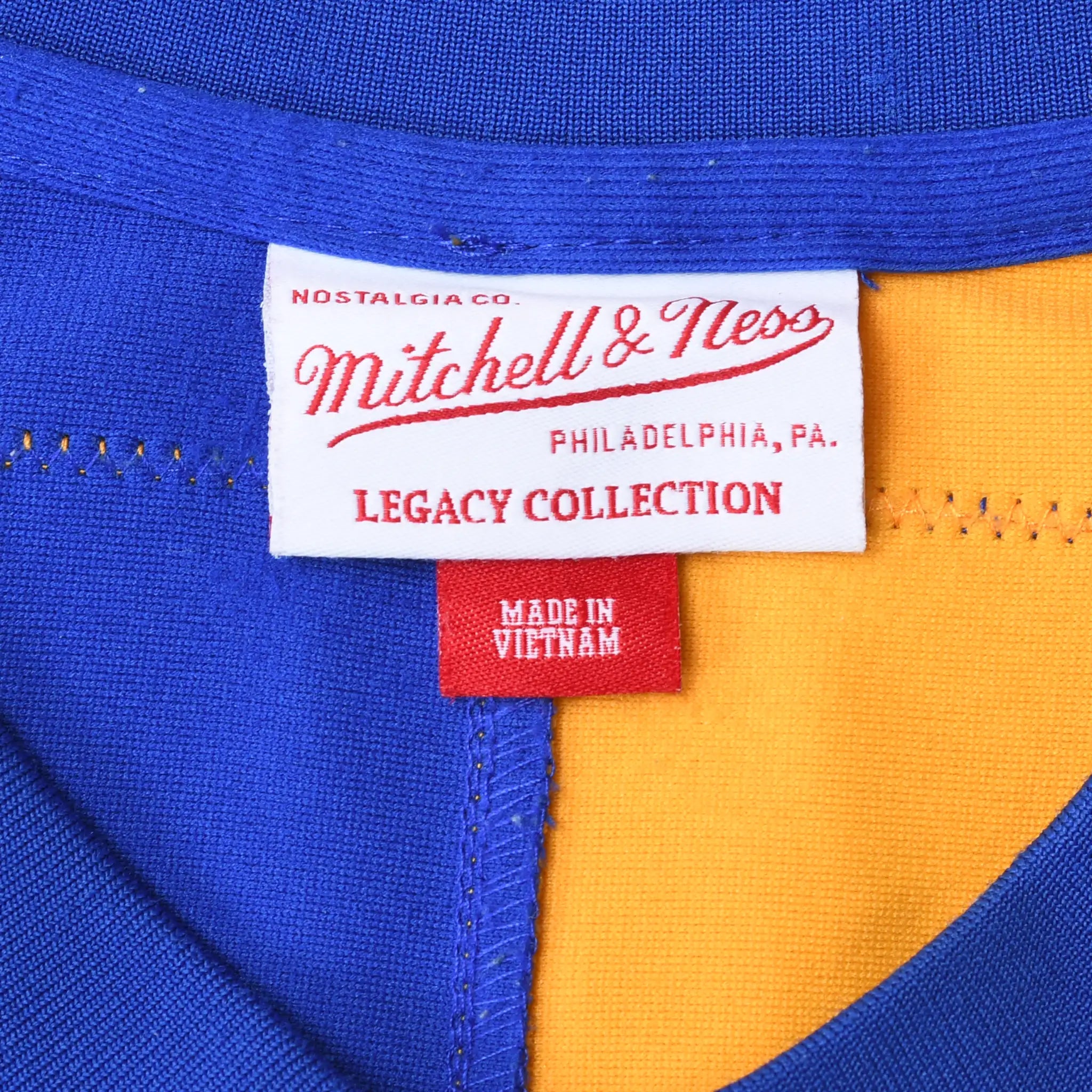 Mitchell & Ness Legacy Collection neck label on blue and gold jersey
