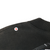 Close-up of black tee shoulder seam and ribbed collar with a small spot marked by an arrow