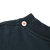 Close-up of black ribbed collar and shoulder seam with arrow marker indicating stitching detail