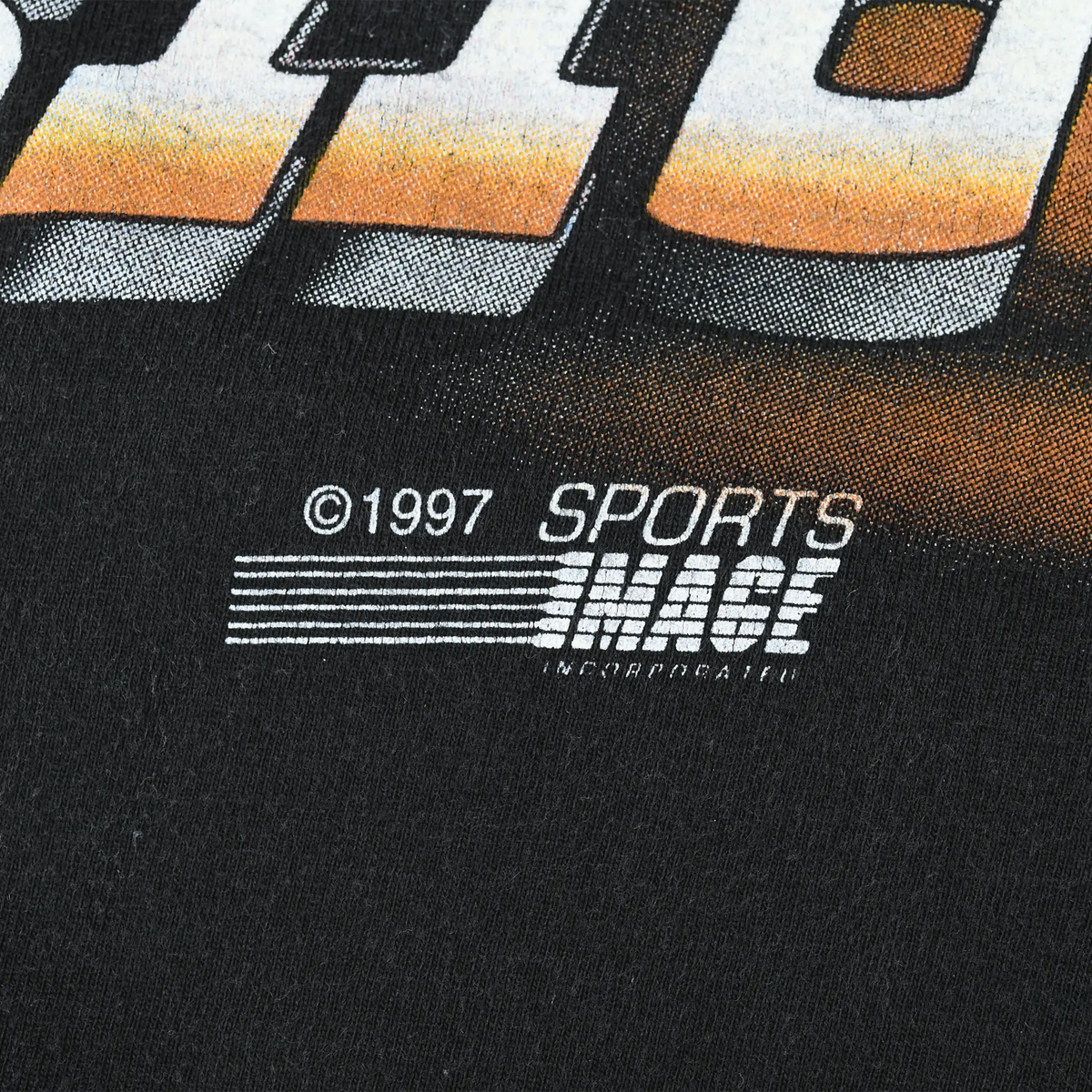 Close-up of 1997 Sports Image copyright mark printed on black fabric