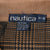 Nautica M size neck label against tan ribbed collar and brown plaid fabric