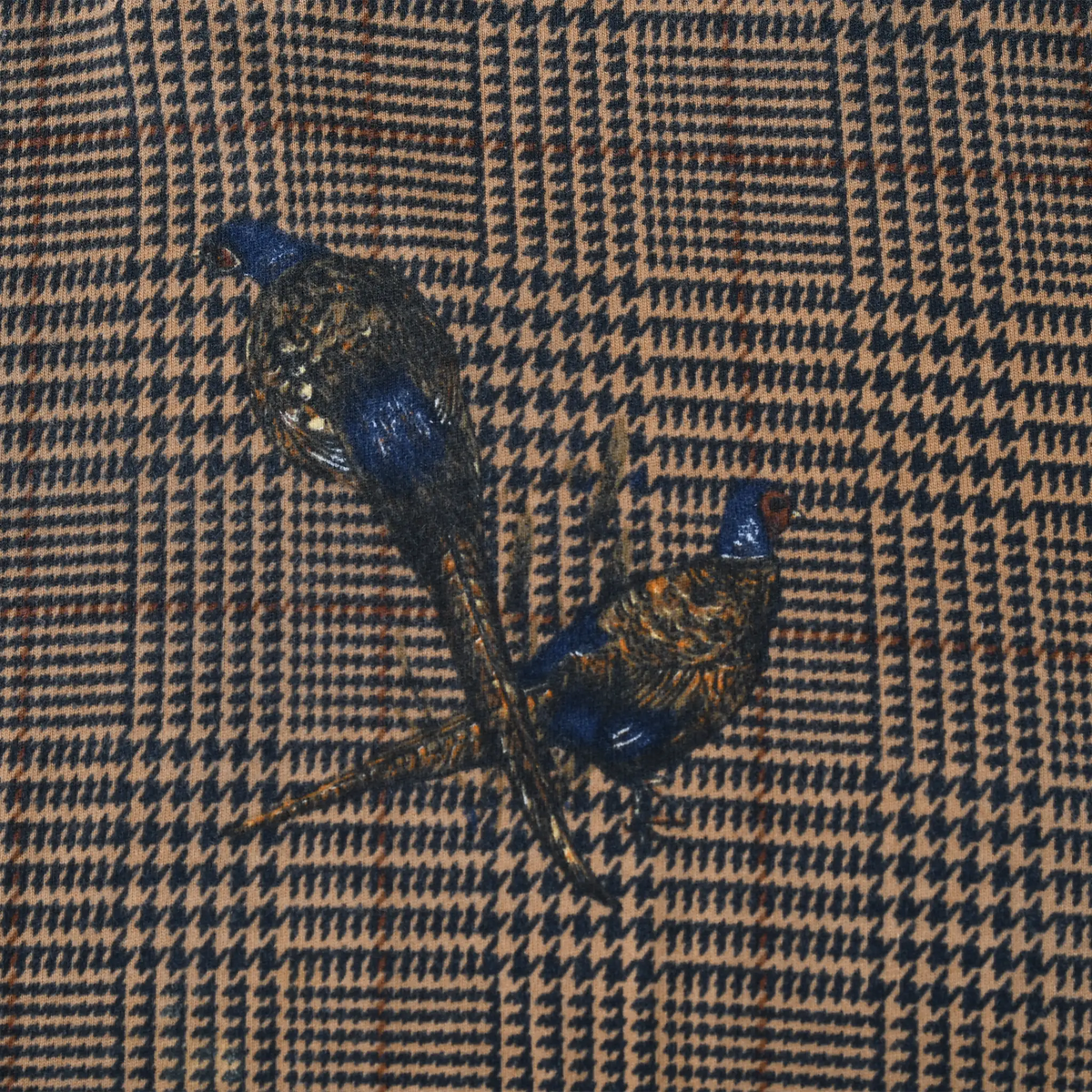 Close-up of two blue and brown pheasants printed on brown plaid fabric