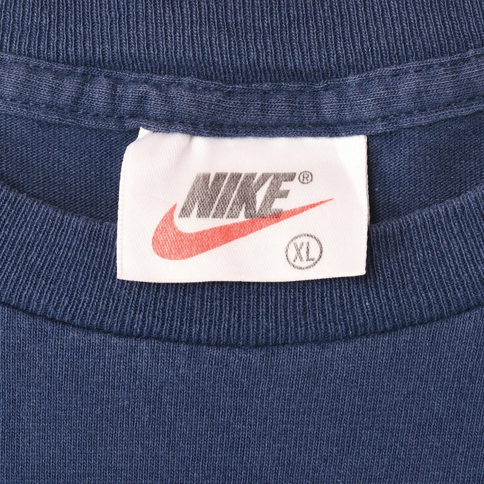 Close-up of Nike neck label marked XL inside blue T-shirt collar
