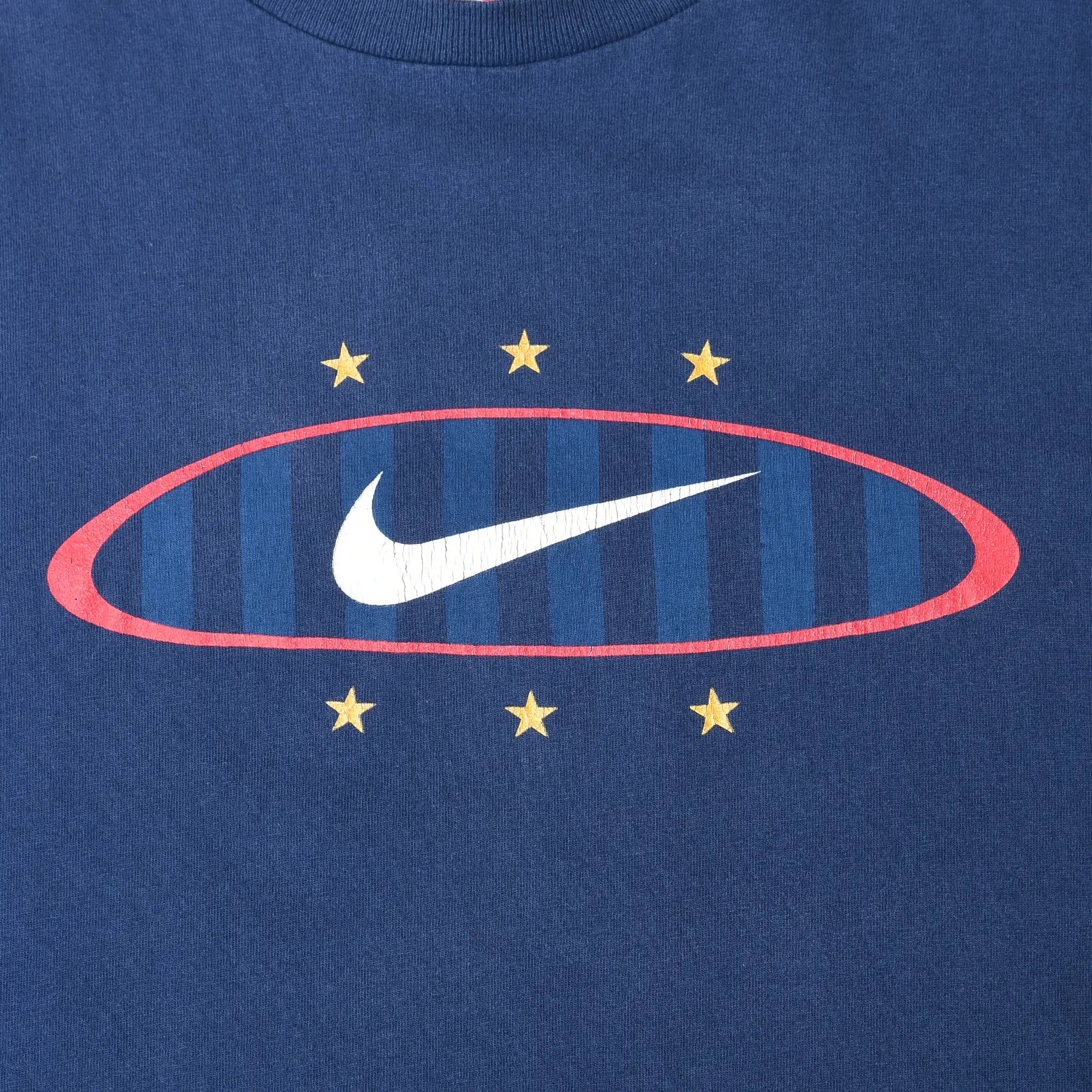 Close-up of front Nike Swoosh graphic with red oval, blue stripes, and six yellow stars