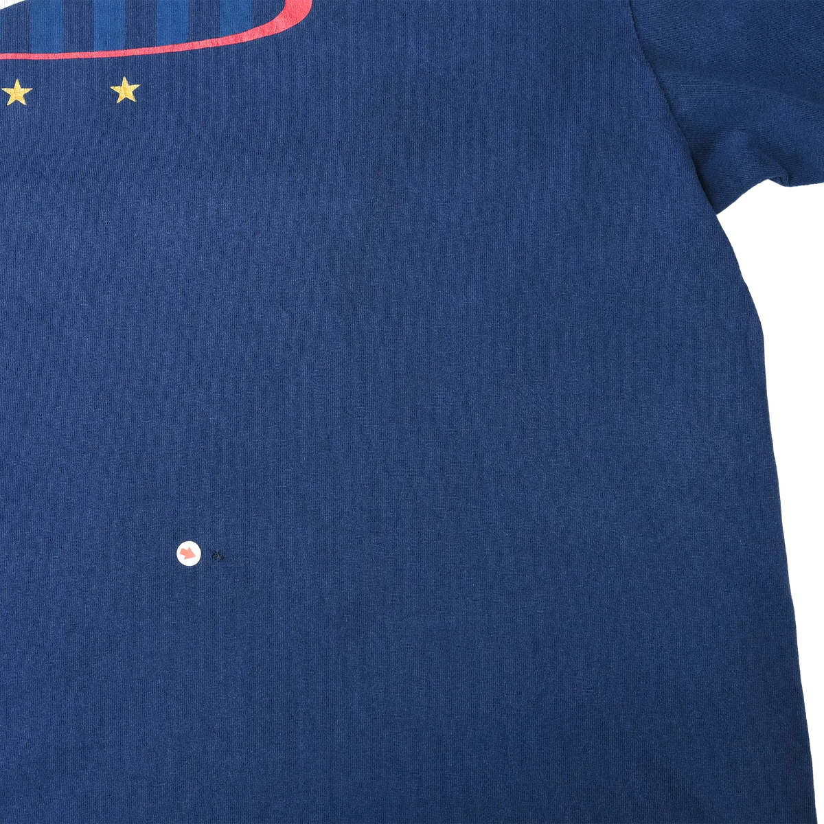 Close-up of blue front fabric showing a small hole below the chest graphic