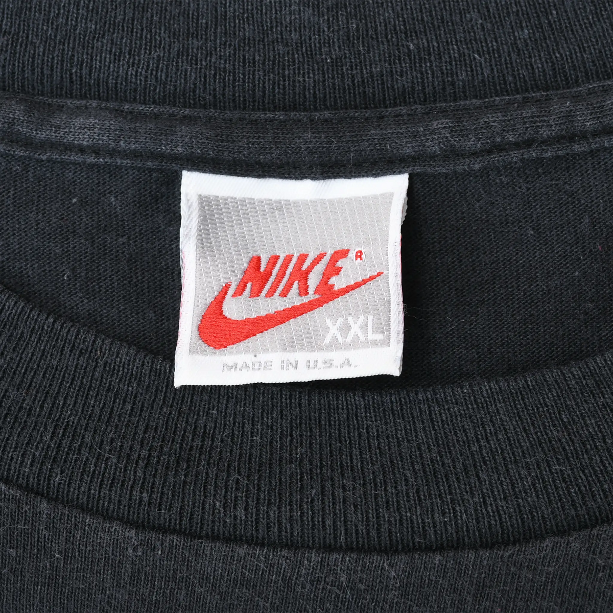 Close-up of Nike XXL Made in U.S.A. neck tag on black T-shirt