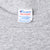 Close-up of Champion Medium neck tag on gray T-shirt