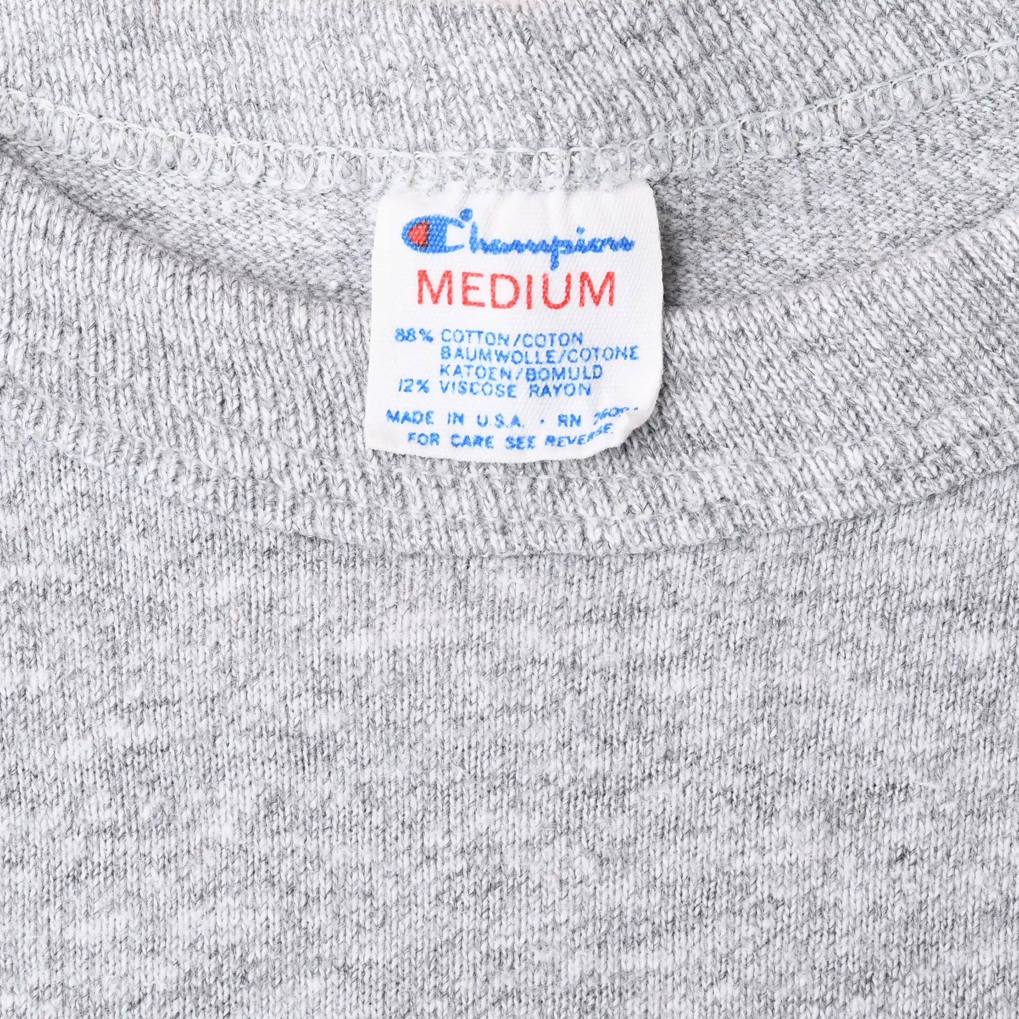 Close-up of Champion Medium neck tag on gray T-shirt