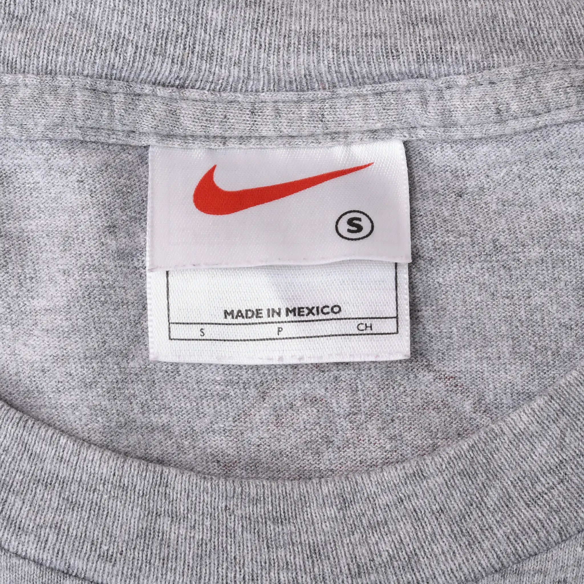 Close-up of Nike neck label showing red Swoosh, size S and Made in Mexico text