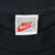 Close-up of white Nike neck tag marked L and Made in U.S.A. inside black T-shirt
