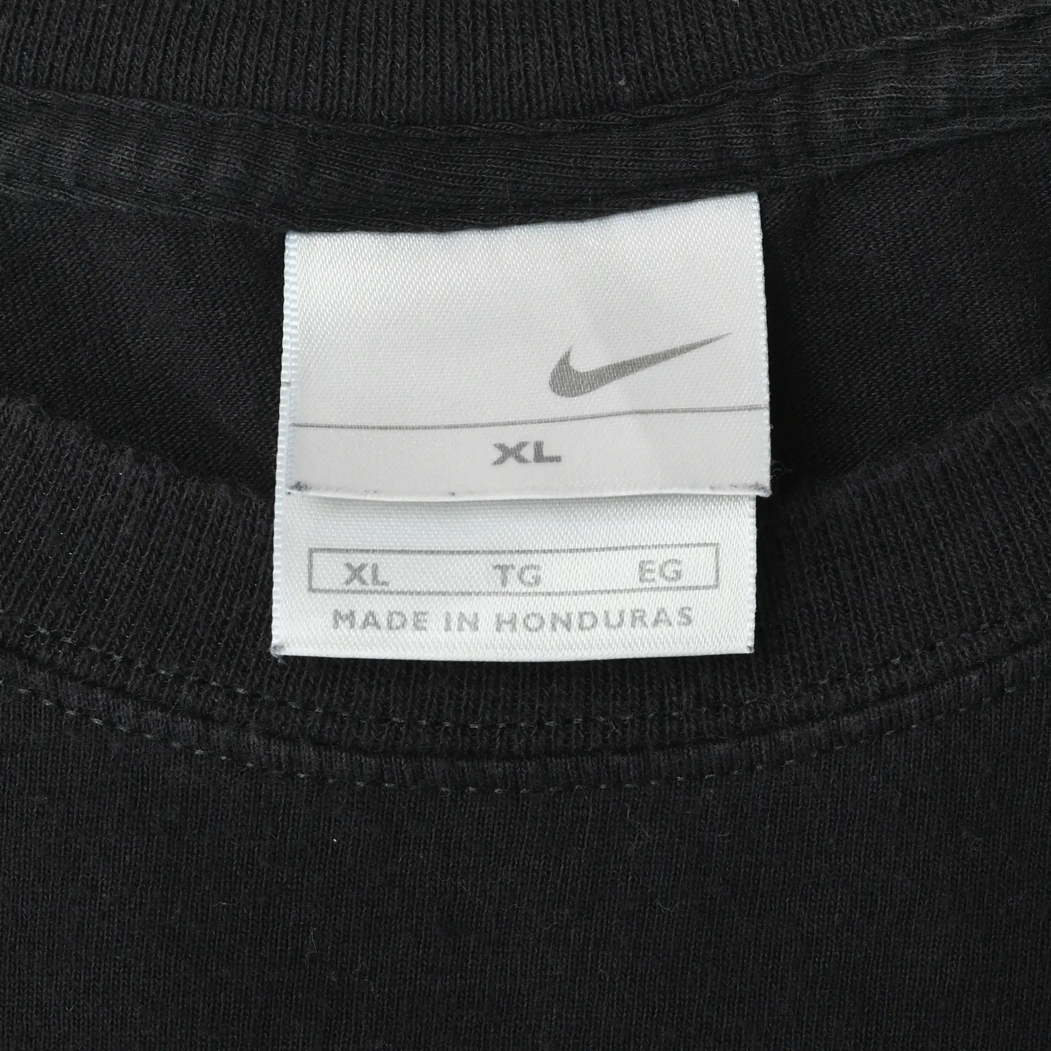 Nike XL neck tag inside black T-shirt, marked Made in Honduras