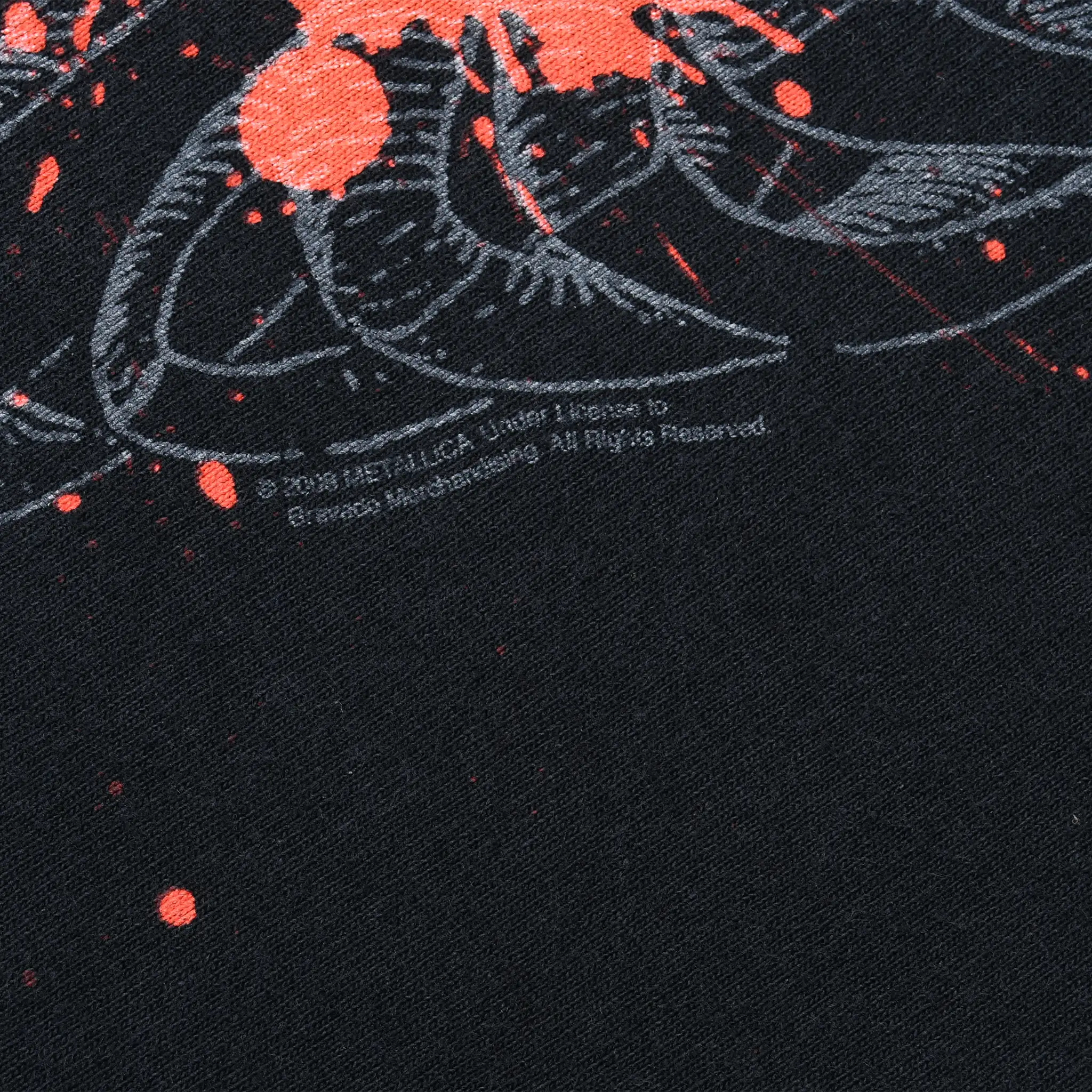 Close-up of small copyright text beneath the red and gray front print on black fabric