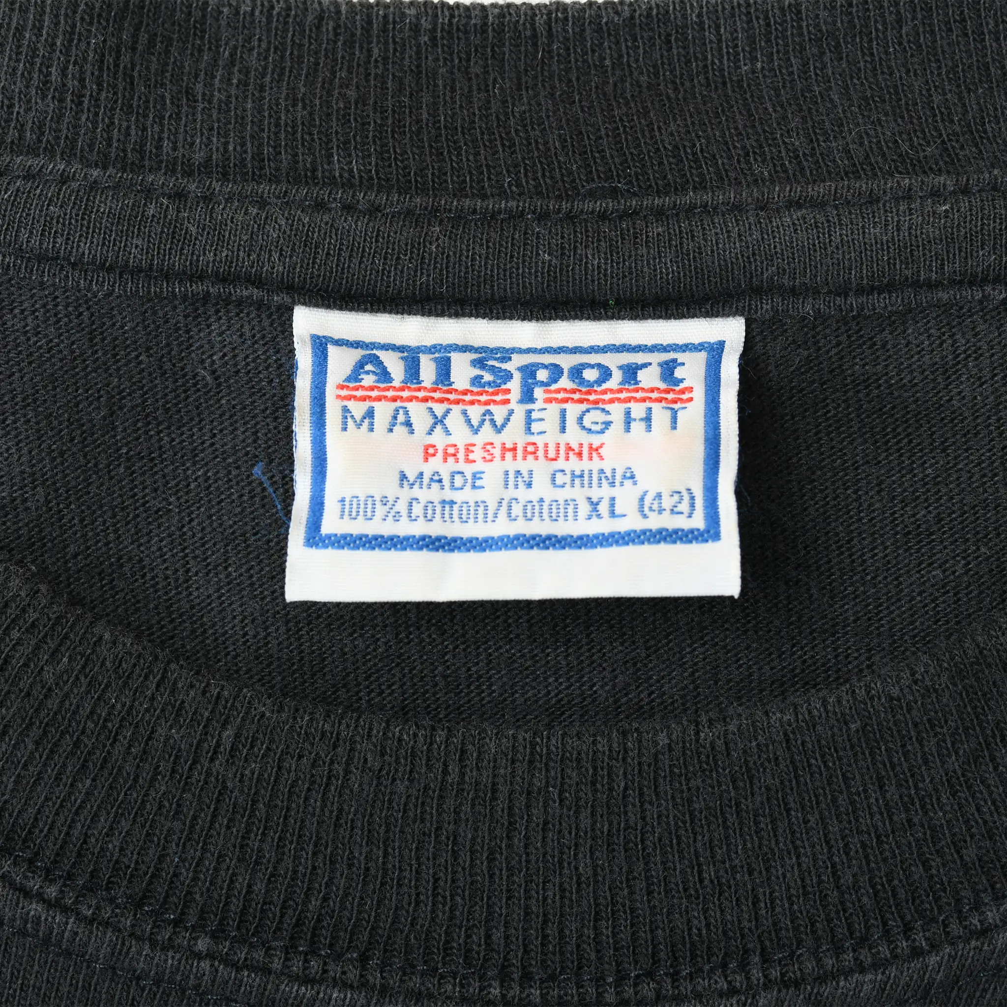 Close-up of Anvil Sport Maxweight neck tag marked preshrunk, 100% cotton, and XL (42)
