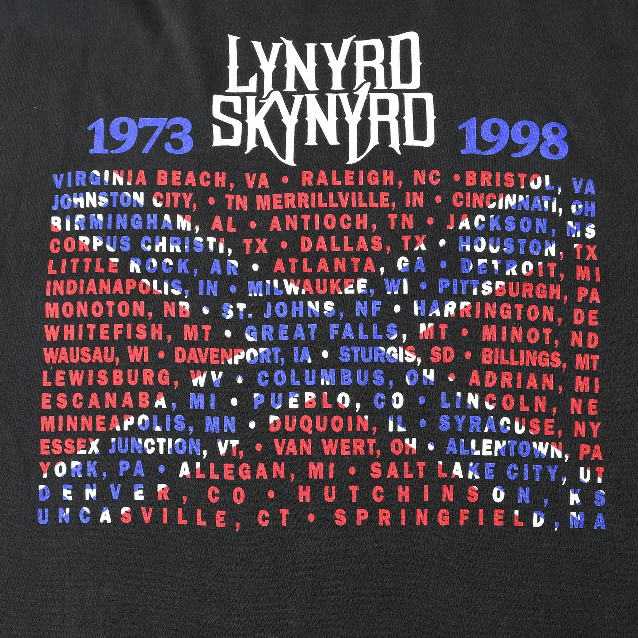 Close-up of back print with Lynyrd Skynyrd 1973–1998 heading and red, white, and blue city list
