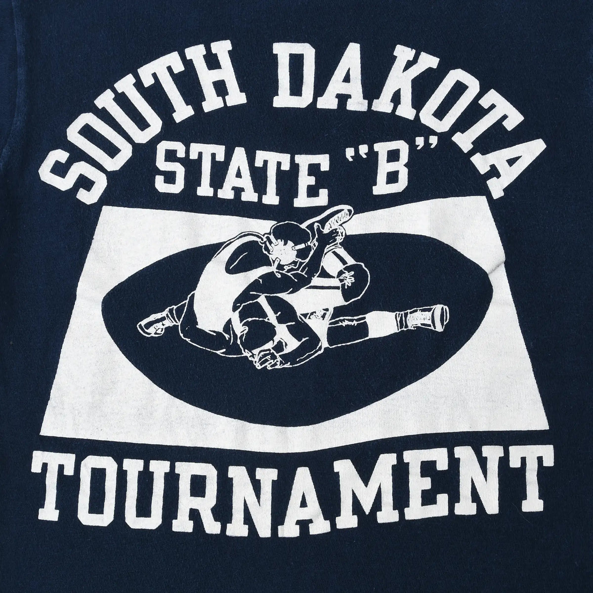 Close-up of white South Dakota State B tournament print with two wrestlers