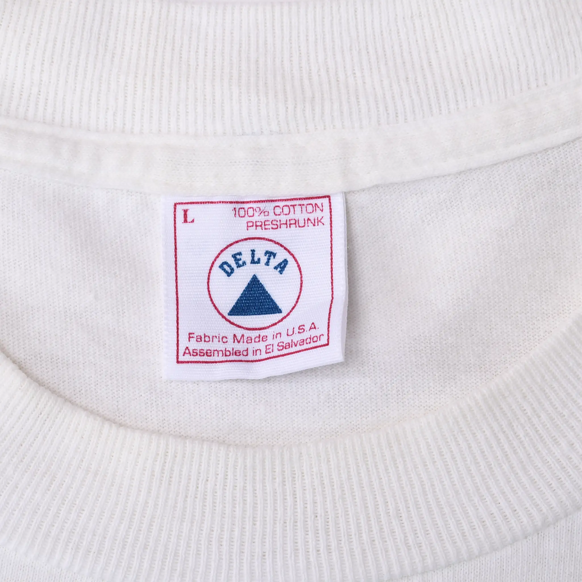 Close-up of Delta large neck tag reading 100% cotton, preshrunk and fabric made in USA