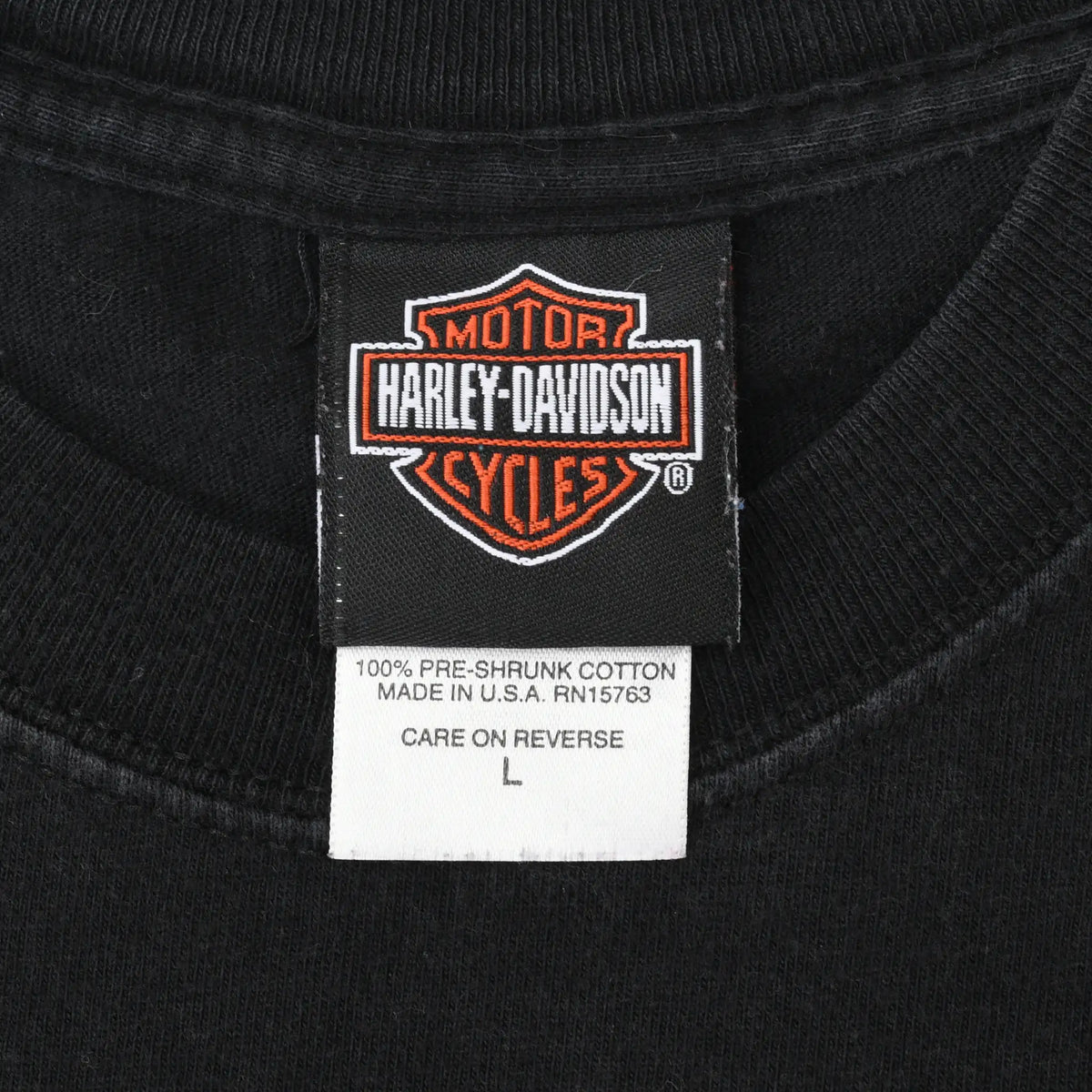 Harley-Davidson neck tag showing size L, 100% pre-shrunk cotton, and Made in USA text