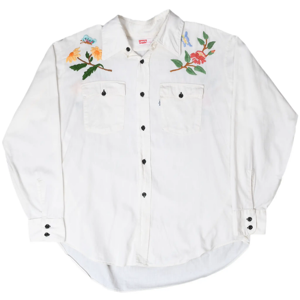 Full front view of white Levi's long-sleeve shirt with floral embroidery, two pockets, and black buttons