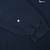 Close-up of navy blue sweatshirt sleeve showing a small hole near the ribbed cuff