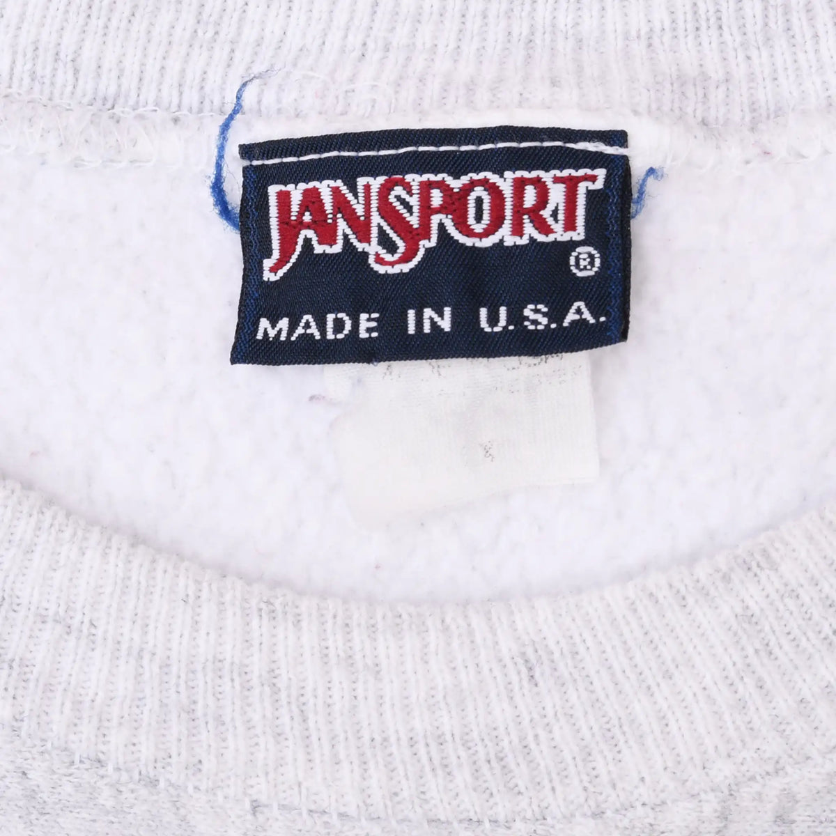 Close-up of Jansport Made in U.S.A. neck label on gray sweatshirt