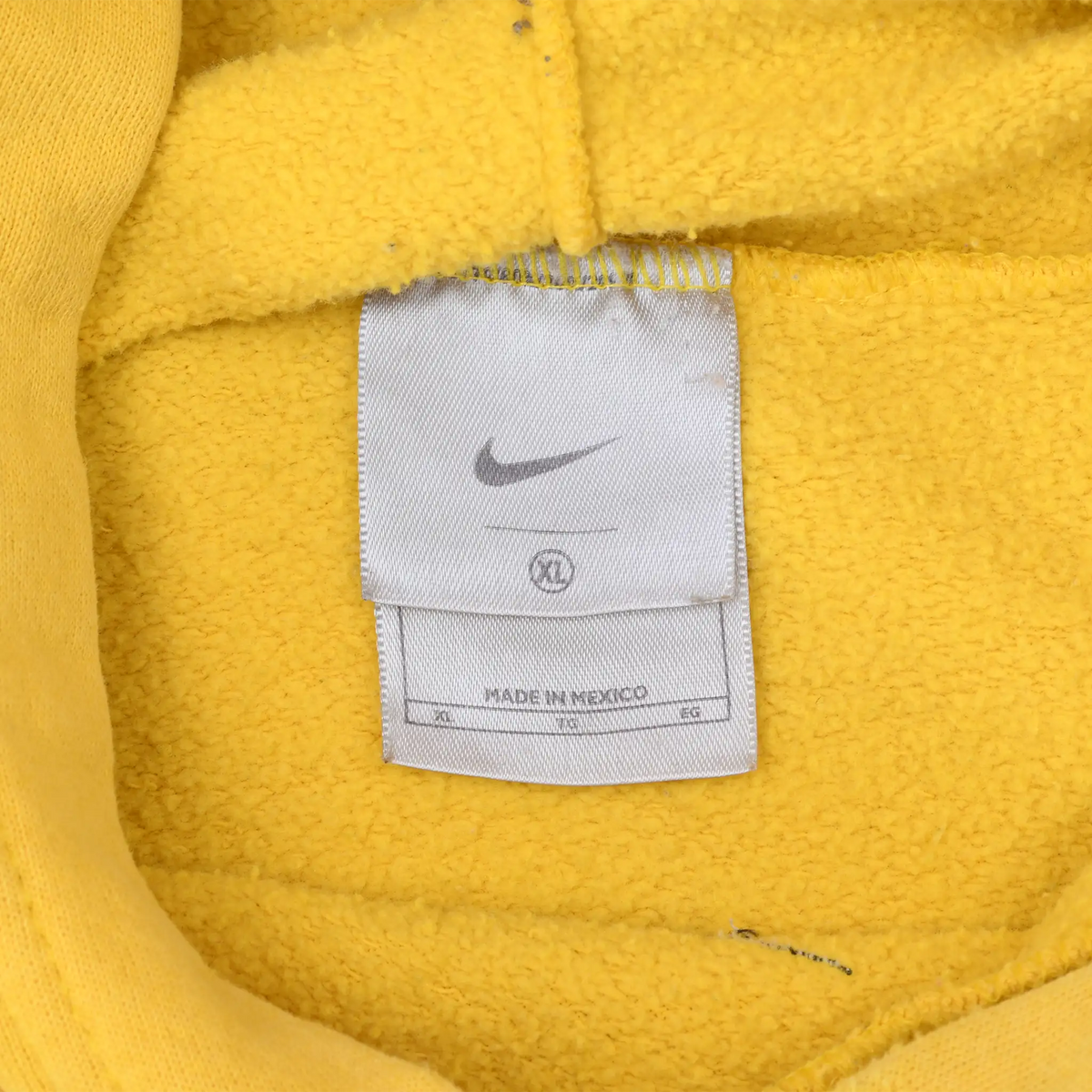 Close-up of Nike neck label inside the yellow hoodie, marked Made in Mexico