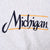 Close-up of navy Michigan script chest embroidery with maize accent lines