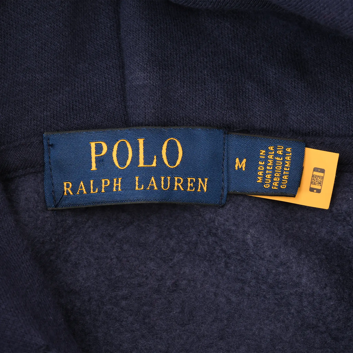 Close-up of Polo Ralph Lauren neck label and medium size tag inside navy hoodie