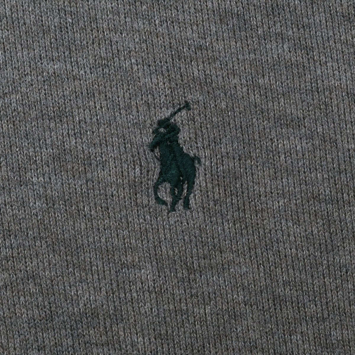 Close-up of dark green Polo pony embroidery on grey sweater fabric