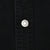 Close-up of silver Levi Strauss branded snap on black denim shirt placket