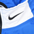 Black Nike Swoosh embroidery on white collar panel of blue windbreaker jacket