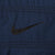 Close-up of black Nike Swoosh embroidery on navy blue jacket chest