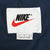 Nike neck label with black logo, red Swoosh, and L size marking