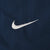 Close-up of white Nike Swoosh embroidery on navy fabric