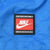 Close-up of red, white, and black Nike Team Sports patch on blue jacket