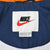 Nike neck label and size tag inside navy blue windbreaker jacket