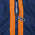 Close-up of navy zipper and Nike Swoosh pull between orange trim