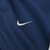 Close-up of white embroidered Nike Swoosh on navy blue jacket fabric