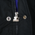 Close-up of silver Starter logo zipper pull and snap closures on black jacket